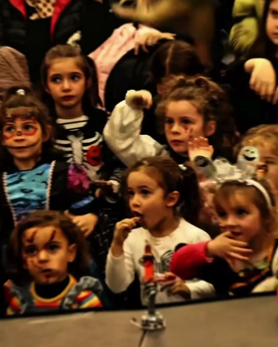 Bambini mascherati in prima fila davanti allo spettacolo
